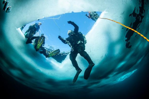 Winter ice diving underwater in a quarry in Canada
